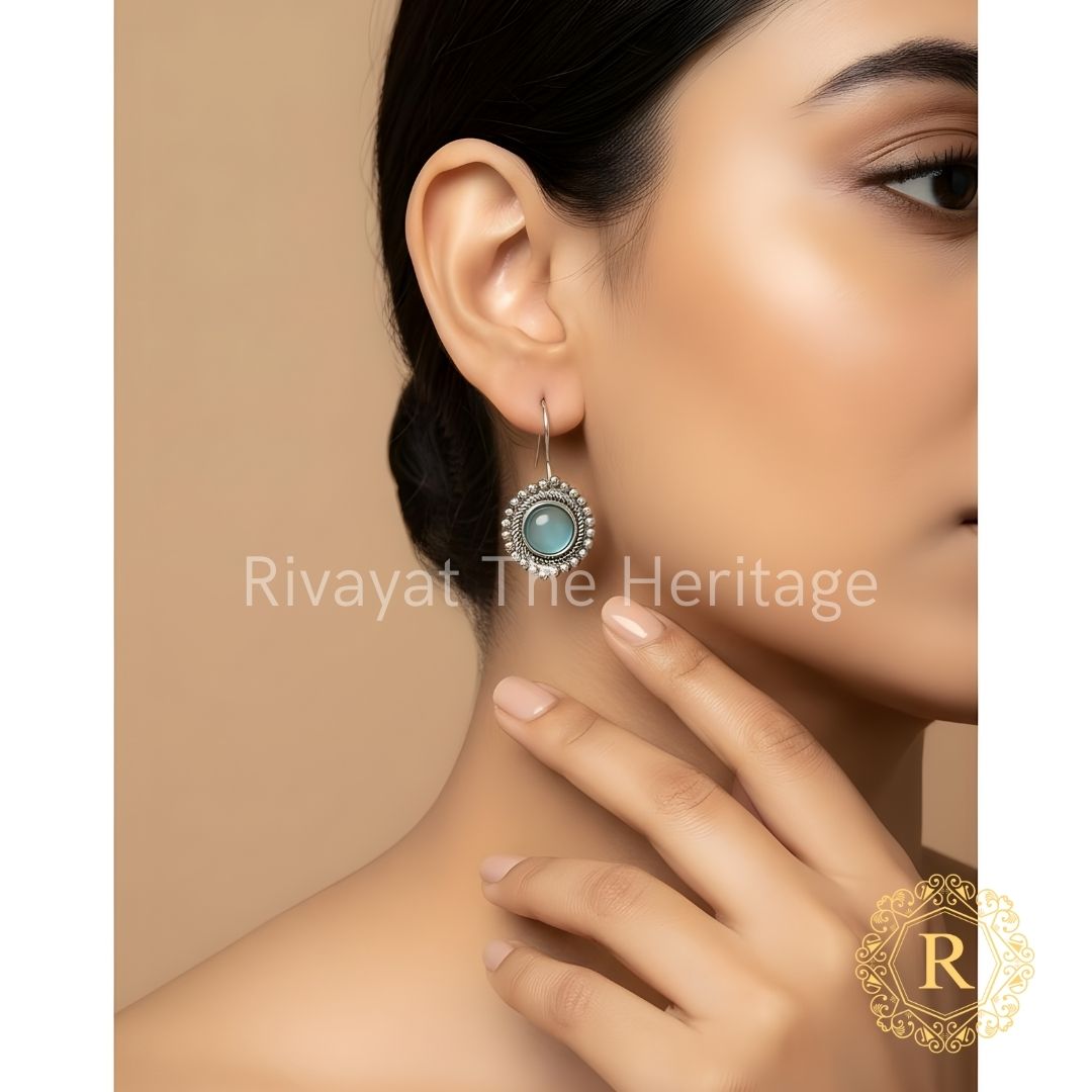 Handcrafted German silver oxidized drop earrings with aqua blue Monalisa stone worn by model