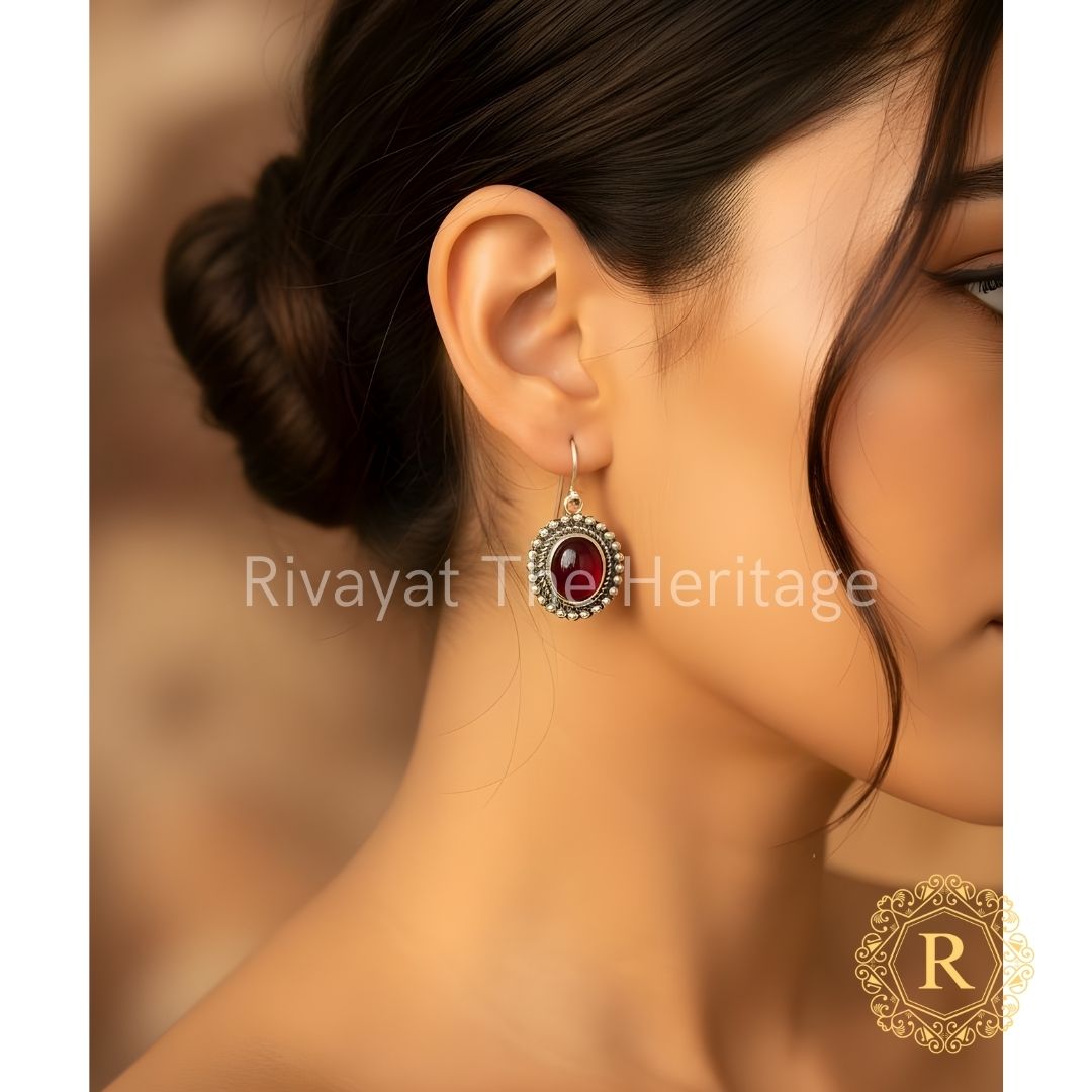 Handcrafted German silver oxidized earrings with red Monalisa stone worn by model