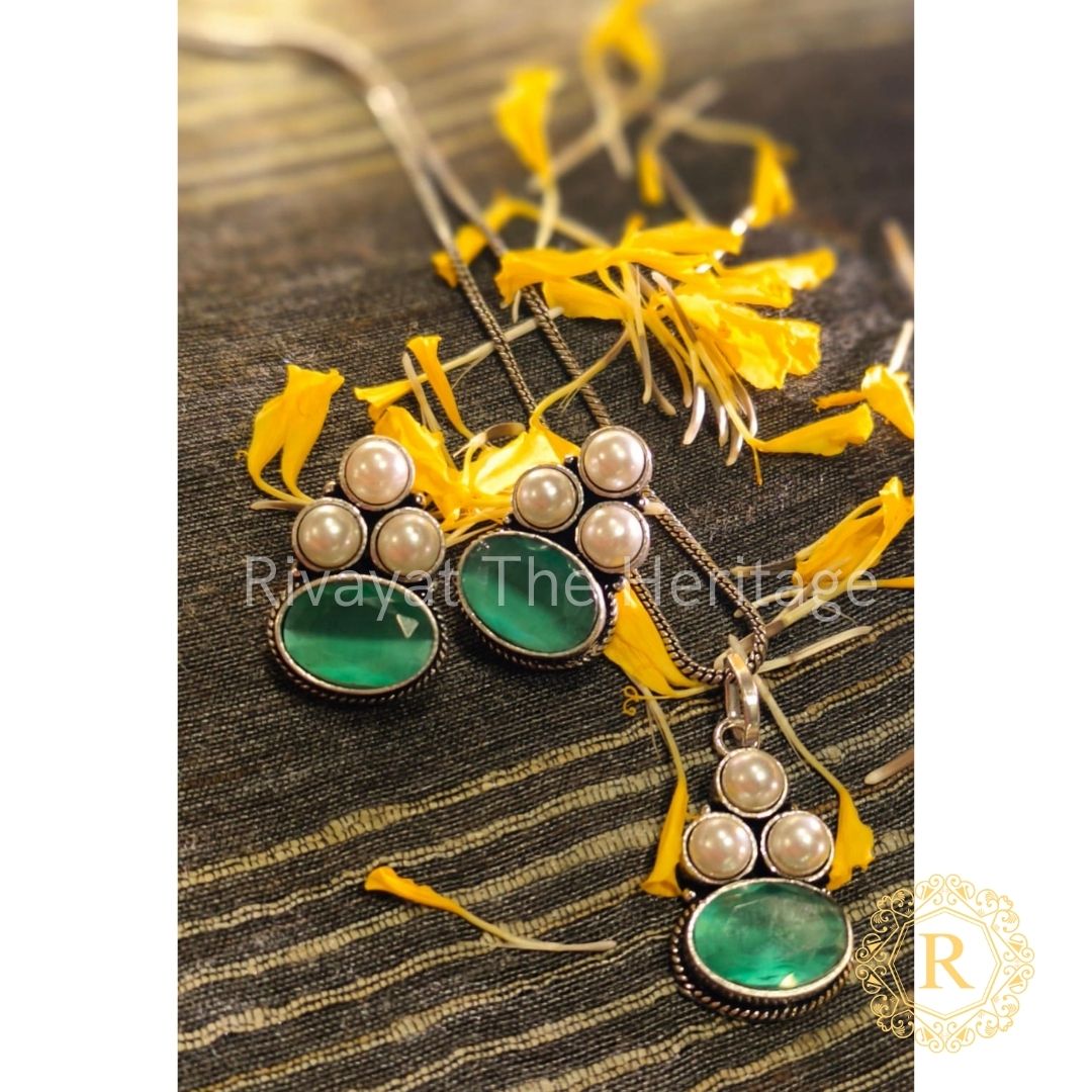 Handcrafted emerald green Monalisa stone German silver oxidized jewelry set with pearl accents on textured fabric background