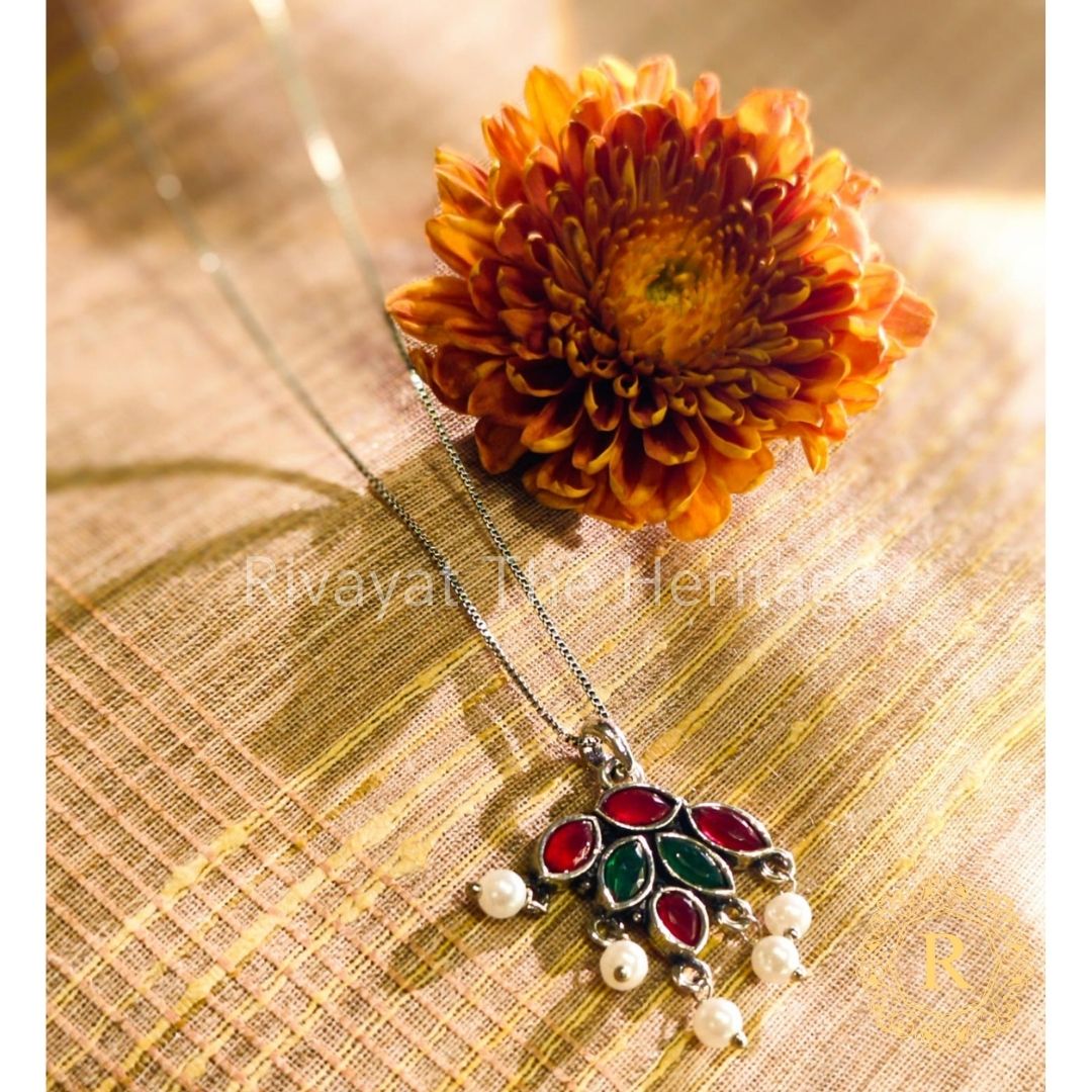 Close-up oxidized German silver floral pendant red green Monalisa stones intricate craftsmanship