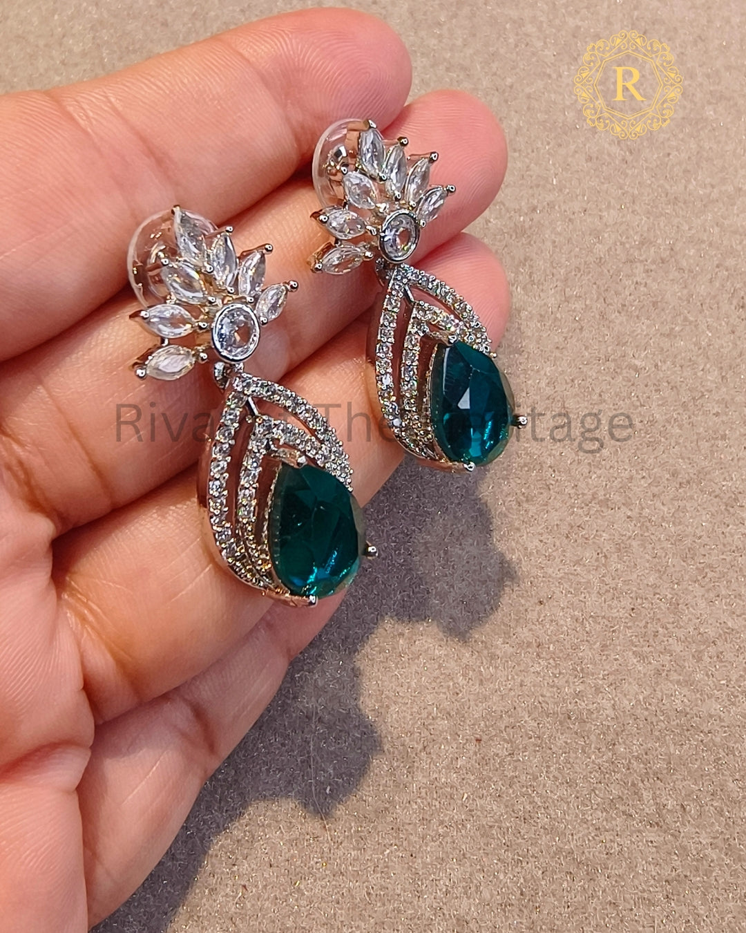Close-up of emerald pear-cut stone with marquise zircon diamond detailing