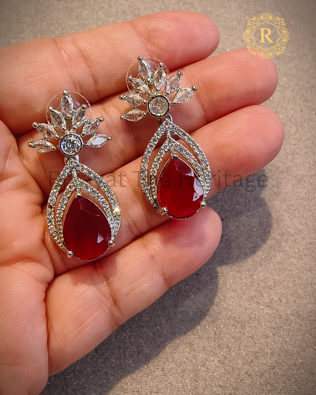 Ruby red zircon diamond pear drop earrings held in hand – Rivayat The Heritage