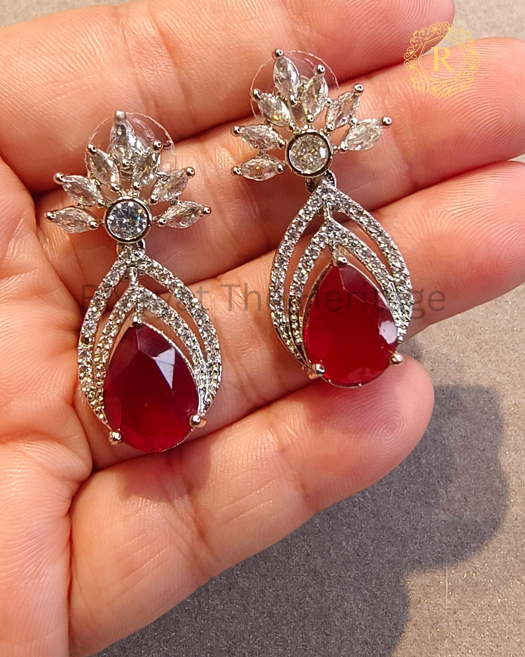 Close-up of ruby red zircon diamond pear drop earrings showing marquise floral detail