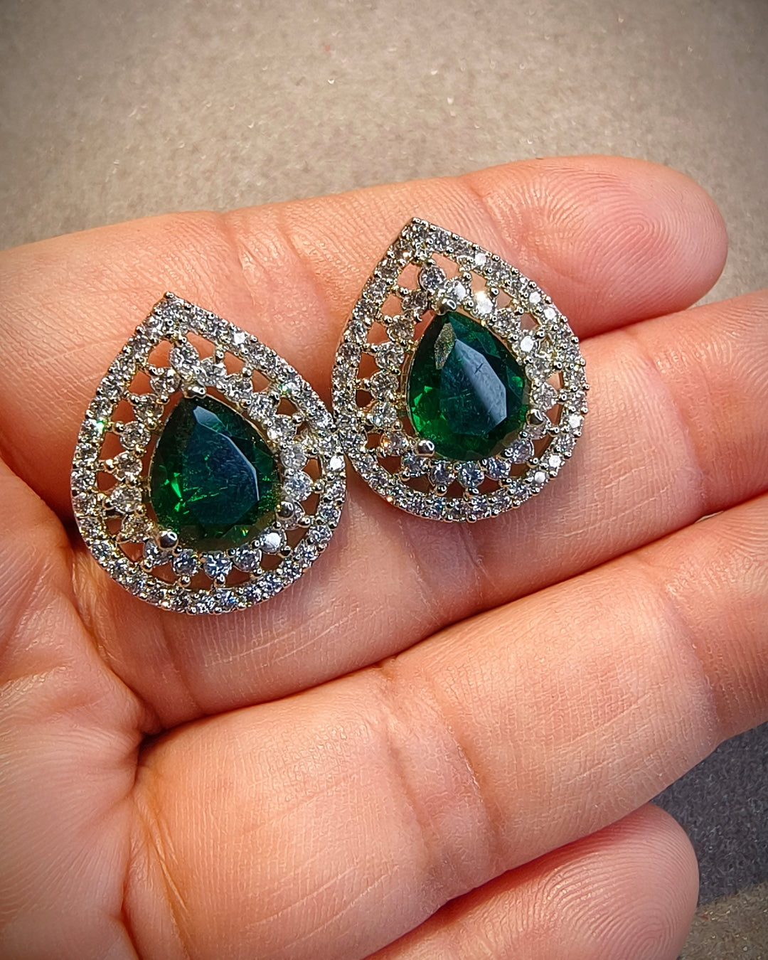 Green zircon teardrop earrings showing detailed zircon stone setting and silver-tone finish