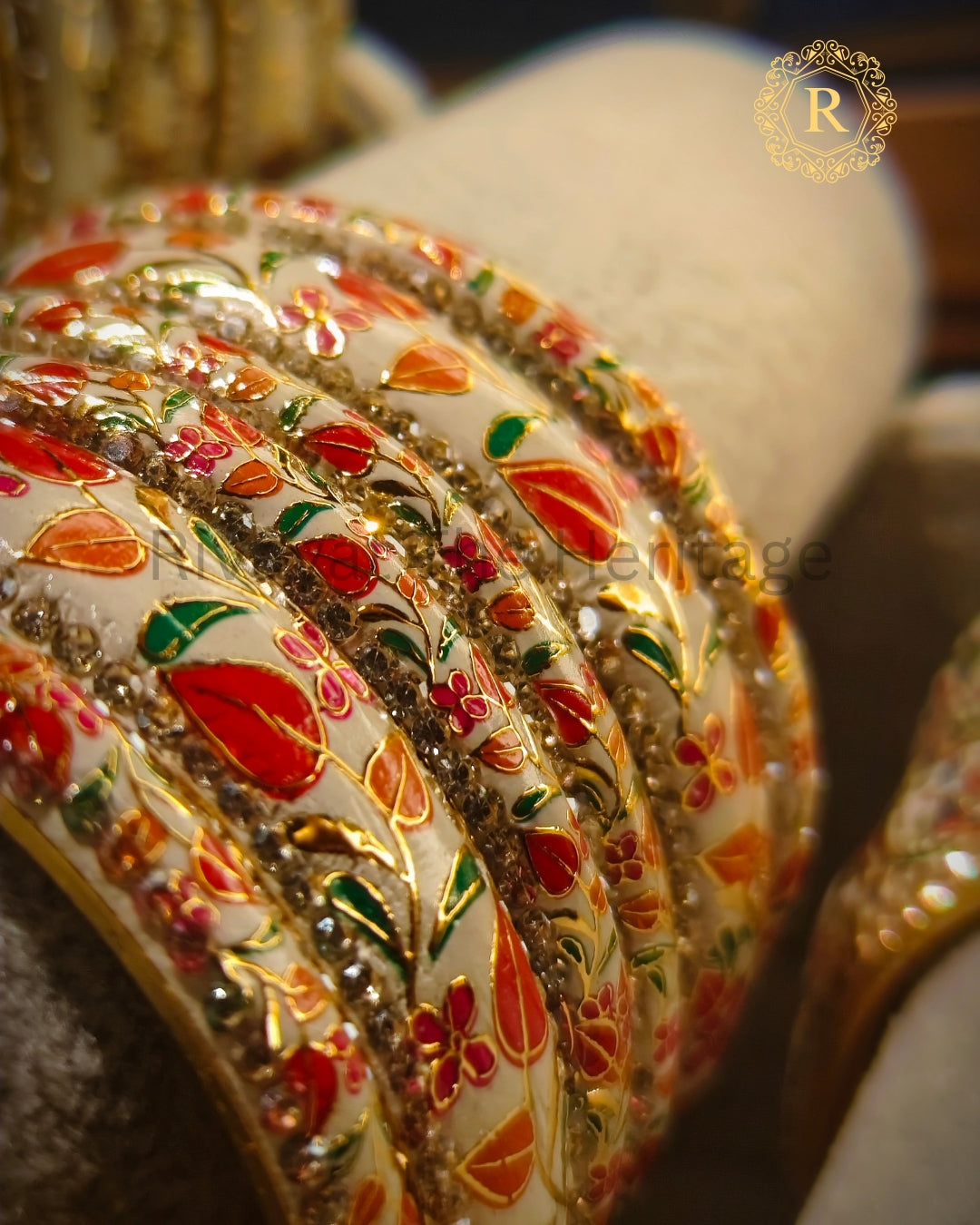 Close-up of handcrafted Meenakari bangle showing floral enamel and gold detailing