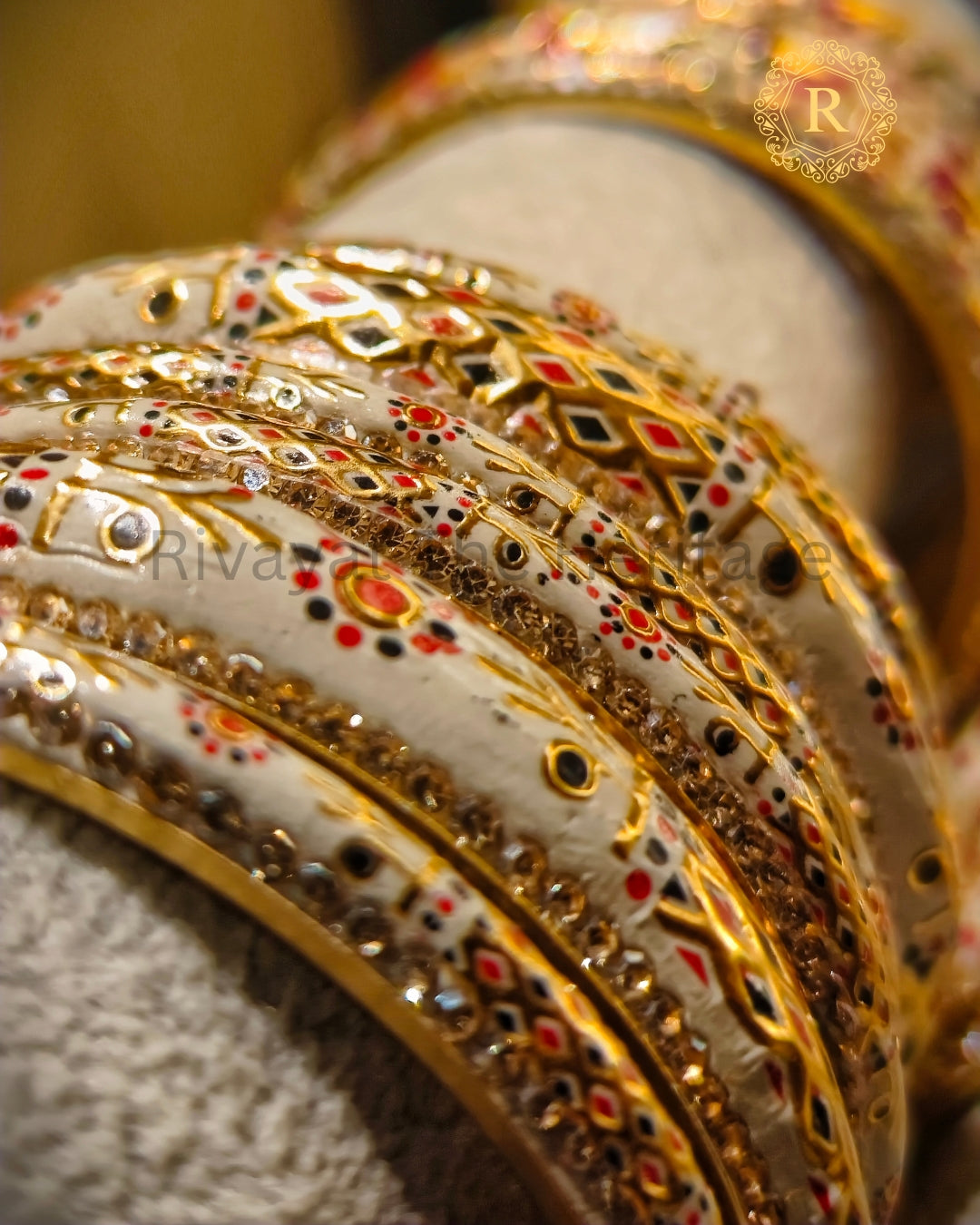 Close-up of hand-painted Meenakari bangles with red and black enamel detailing