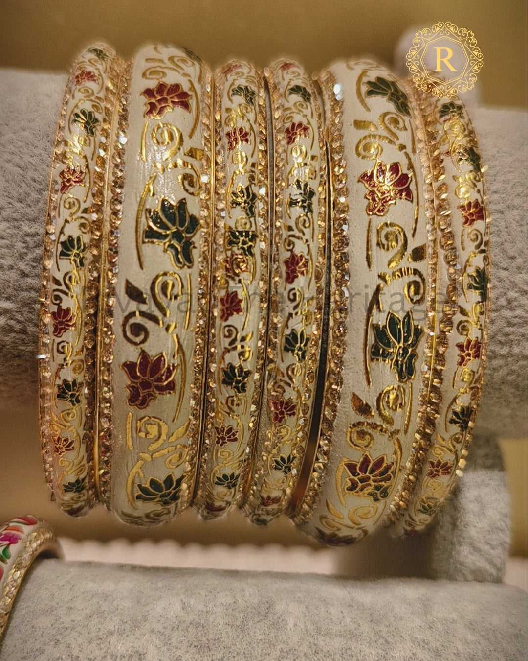 Close-up of handcrafted meenakari bangle set showing gold scrollwork and lotus motifs