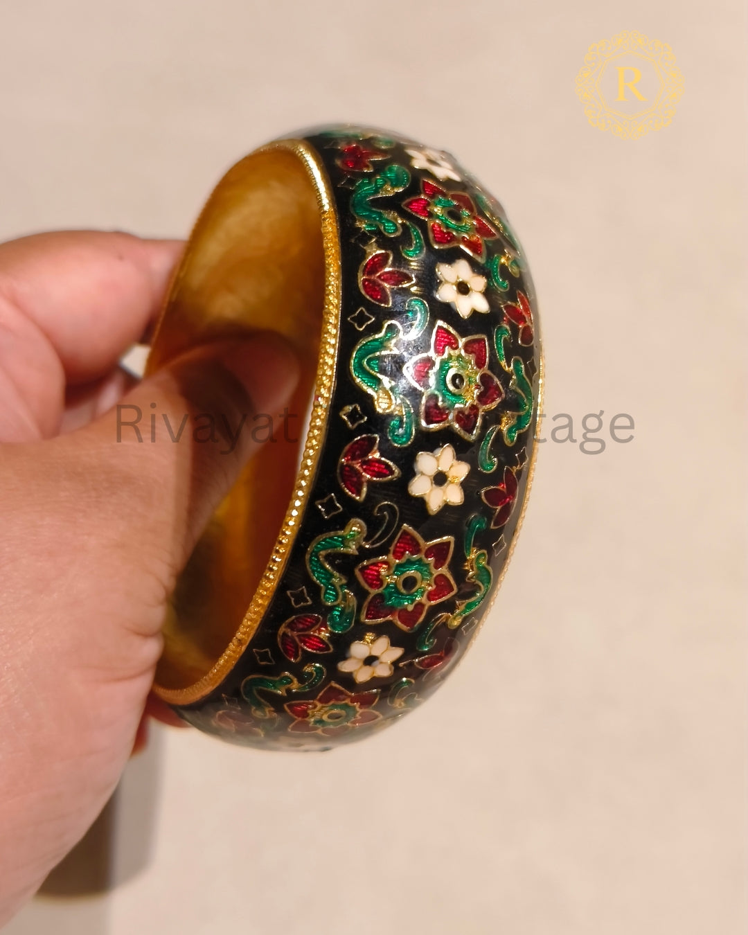 Black Meenakari kada with colourful floral enamel motifs and gold-tone border
