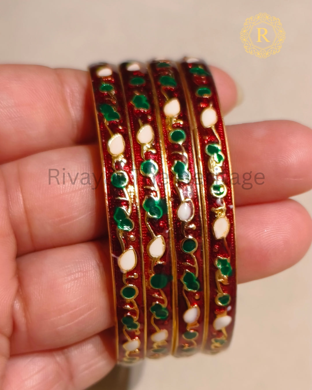 Close-up of handcrafted red Meenakari bangles highlighting traditional enamel work and floral motifs