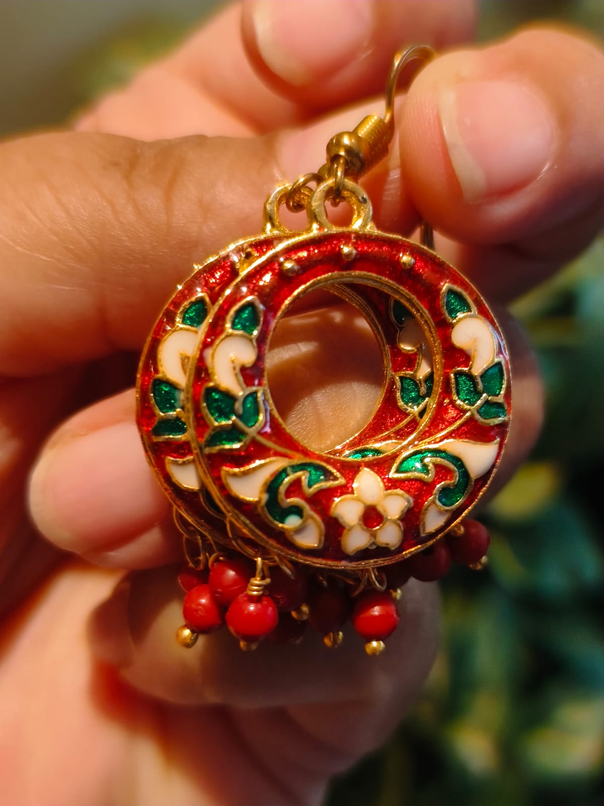 Close-up of red Meenakari chandbali earring with green floral enamel and coral bead drops — Rivayat Manika Collection