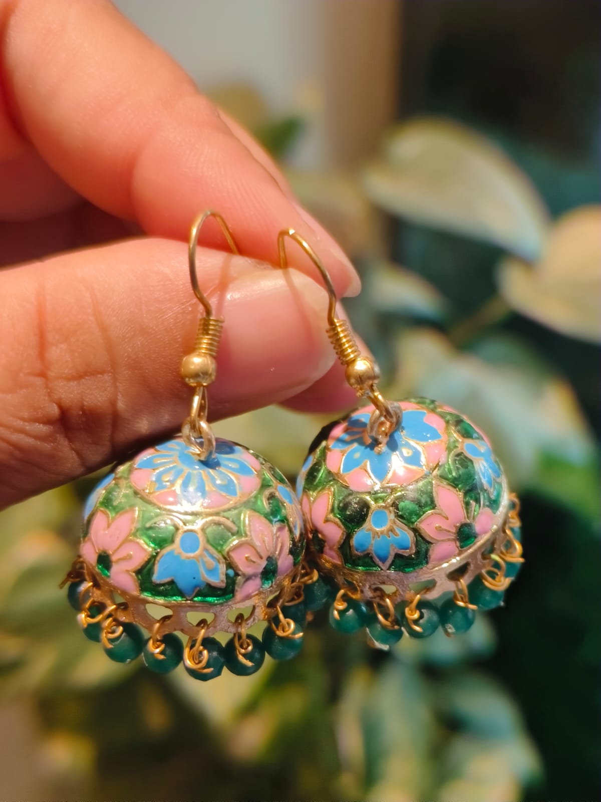 Close-up of Meenakari jhumki showing pink and blue floral enamel work on gold-tone dome – Rivayat Heritage