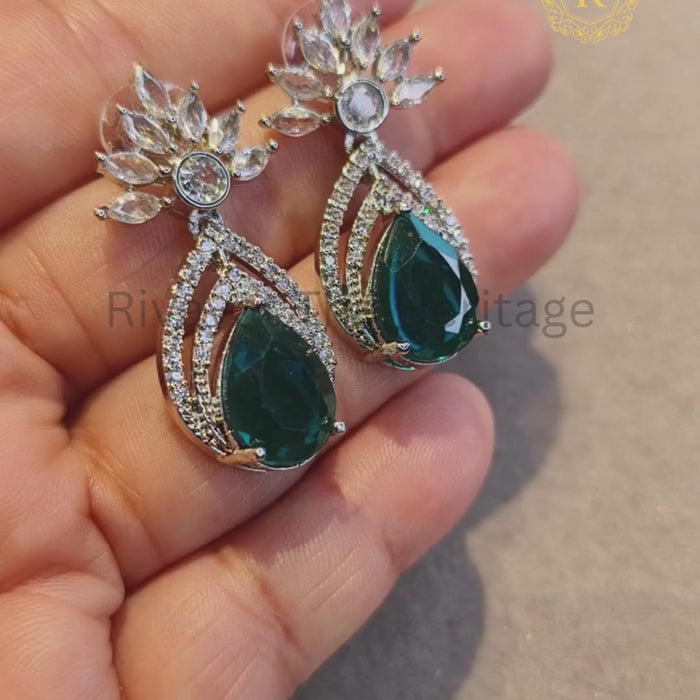 Video showcasing emerald zircon diamond drop earrings with silver rhodium finish, sparkle detail in hand